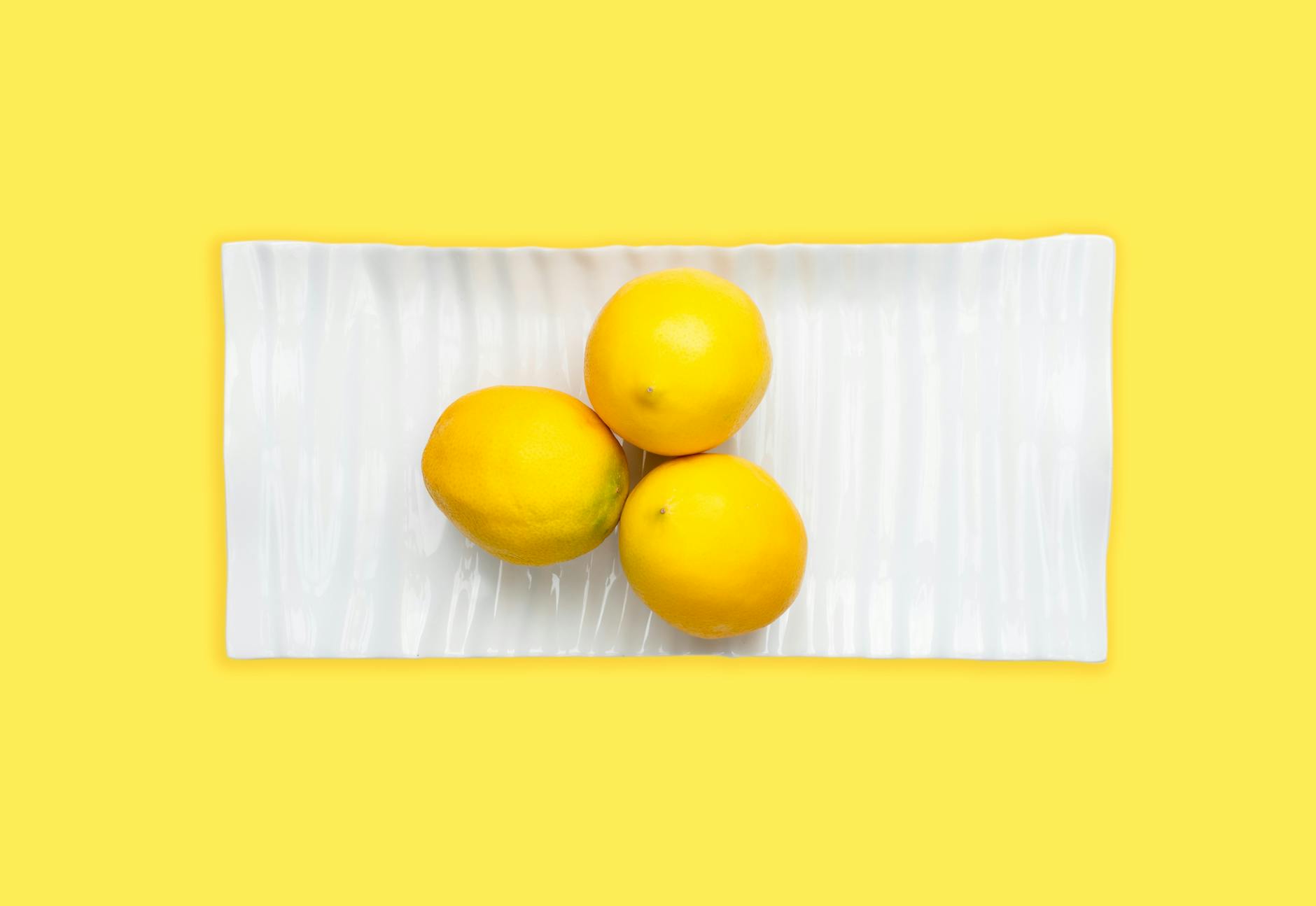 Vibrant collection of colorful clitoral vibrators arranged on a bright yellow surface
