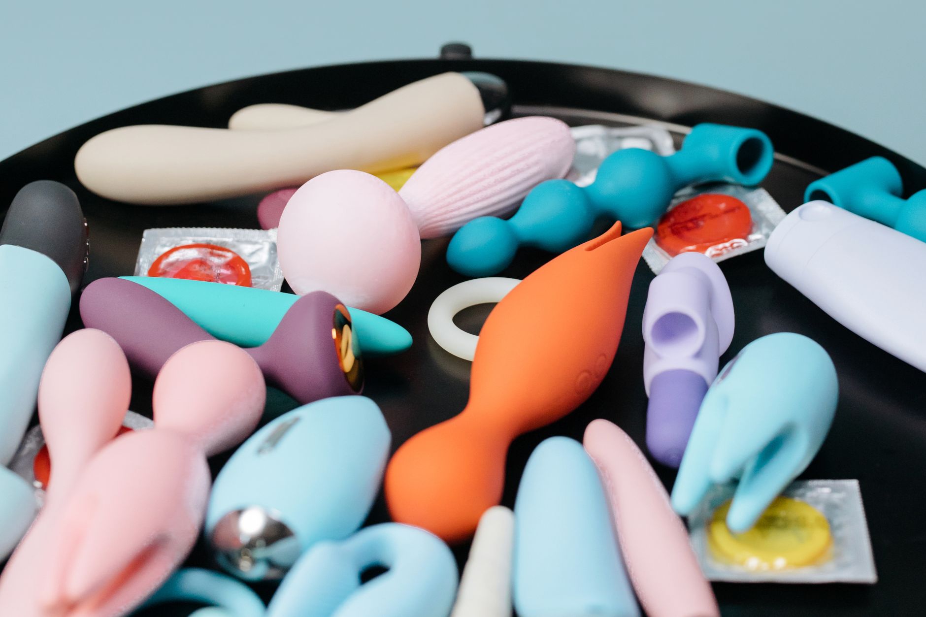 A curated collection of various clitoral vibrators and personal wellness devices on a black tray