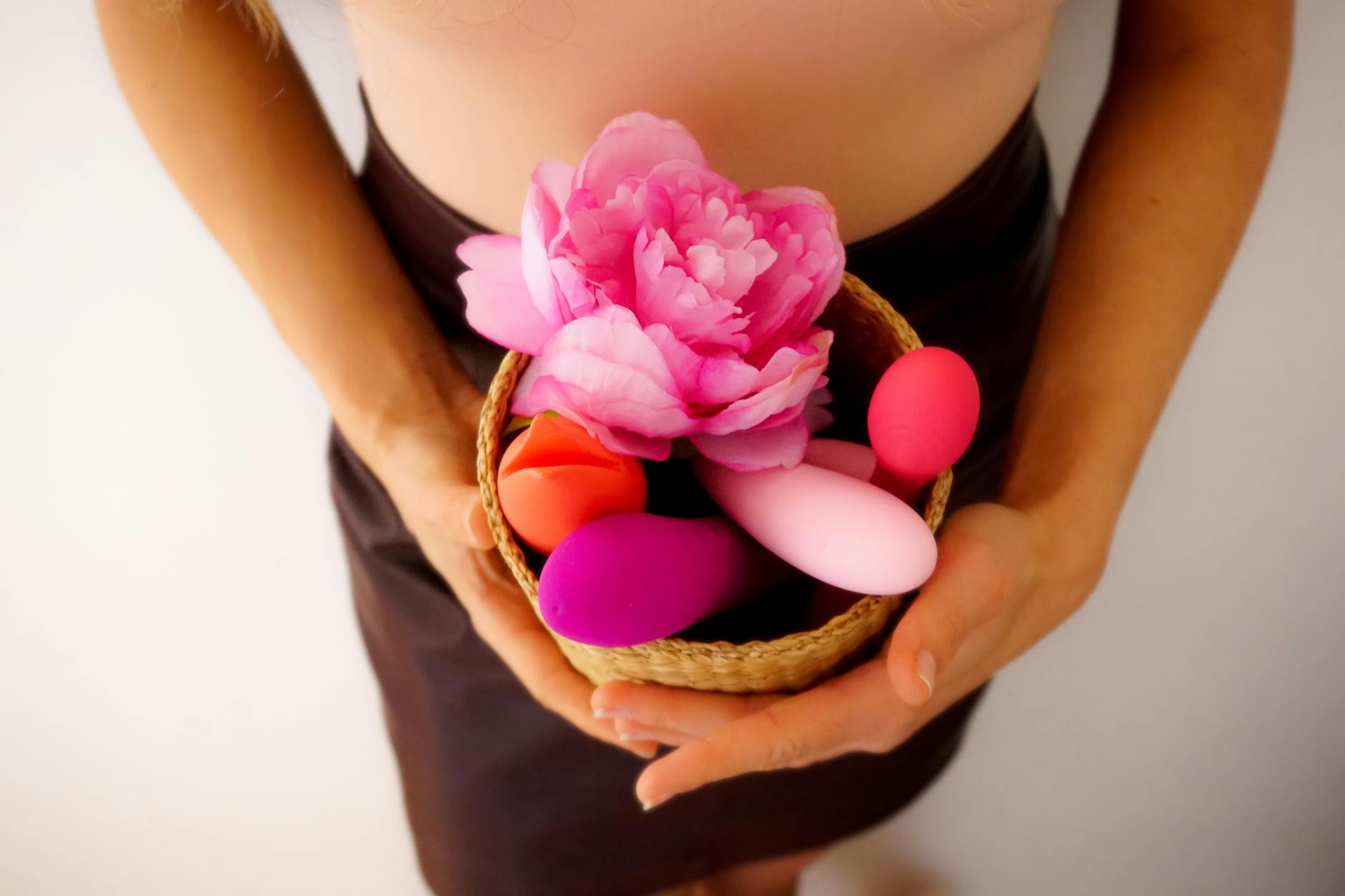 Colorful sex toys arranged on bright yellow background in studio lighting