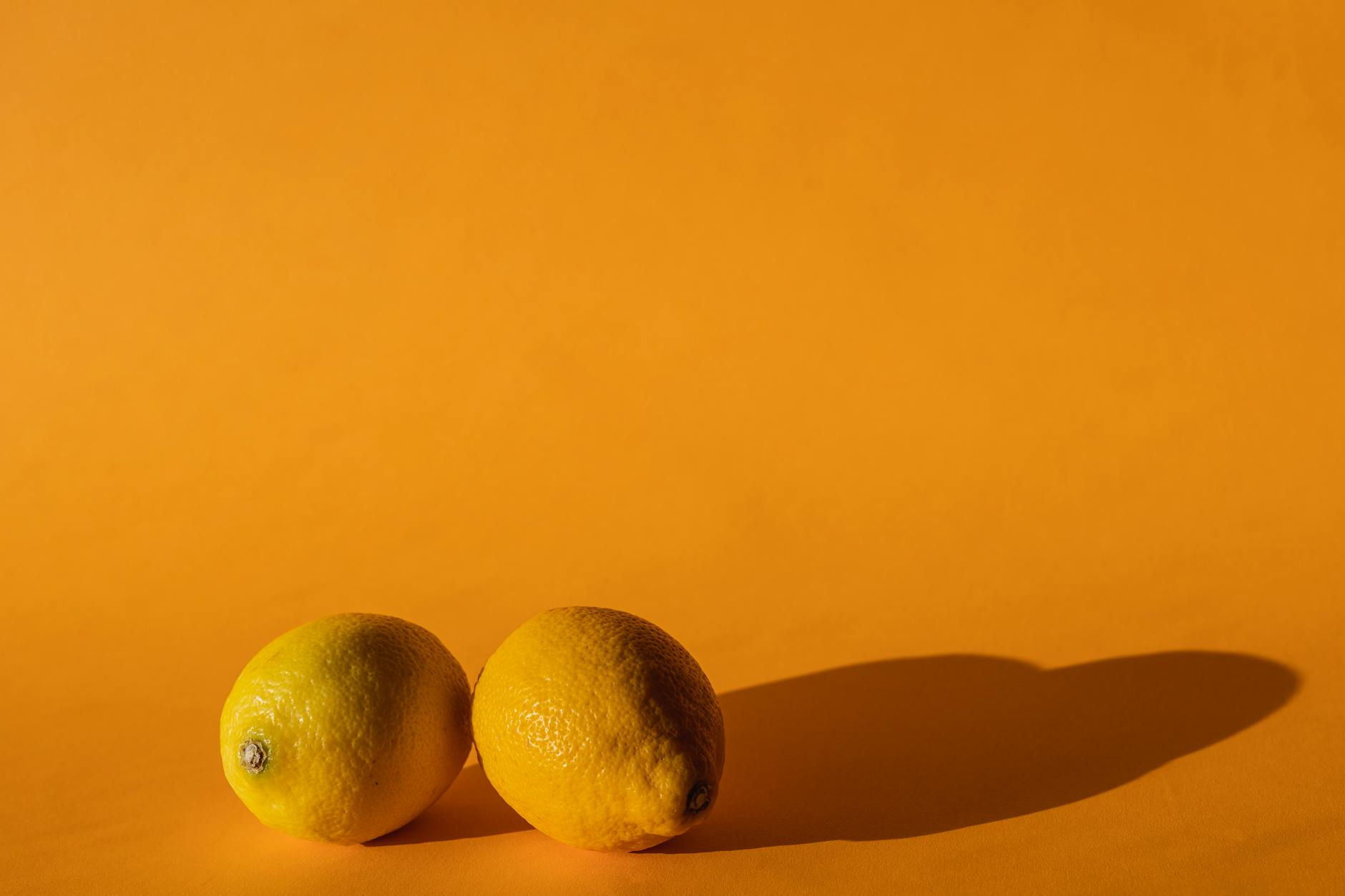 Bright lemons against a yellow background symbolizing the Lemon vibrator